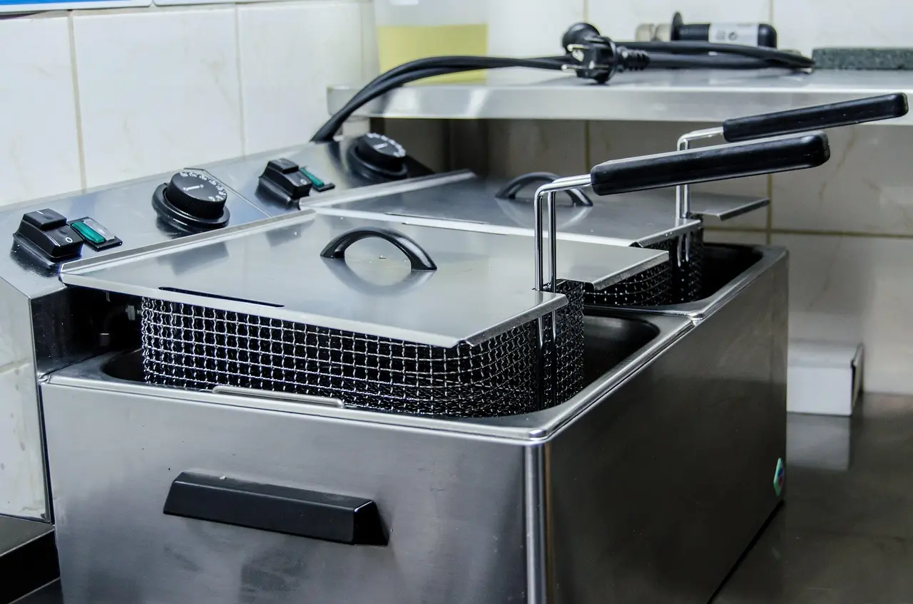 Commercial Deep Fryer with Dual Baskets and Temperature Controls eep fryer with two baskets and adjustable temperature controls in a kitchen setting.
