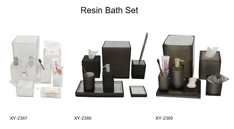 Modern resin bathroom accessory sets in frosted white, translucent smoke grey, and charcoal finishes featuring clear-rimmed vanity trays and square wastebaskets.