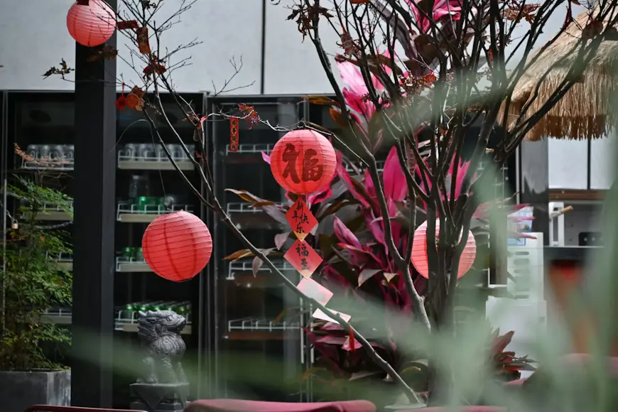 Holiday Peak Season Decorations - Red Lanterns Red Chinese lanterns and festive decorations hanging on trees during the Lunar New Year holiday peak season.