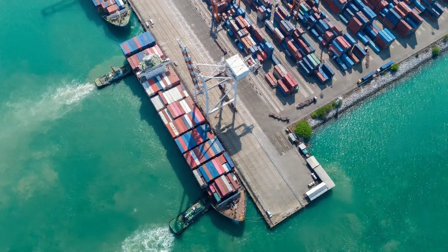 Global shipping and supply chain management for the holiday peak season Aerial view of a large cargo ship at a terminal with colorful containers, representing logistics preparation for the holiday peak season.