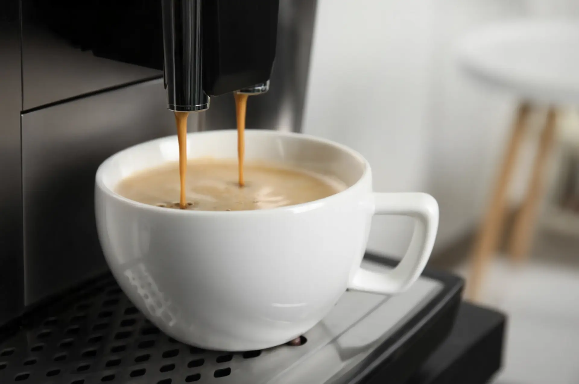 Modern Chinese-made Espresso Machine and Breakfast Setup Black espresso coffee machine made in China on a wooden kitchen counter next to a fresh croissant and white ceramic mug.