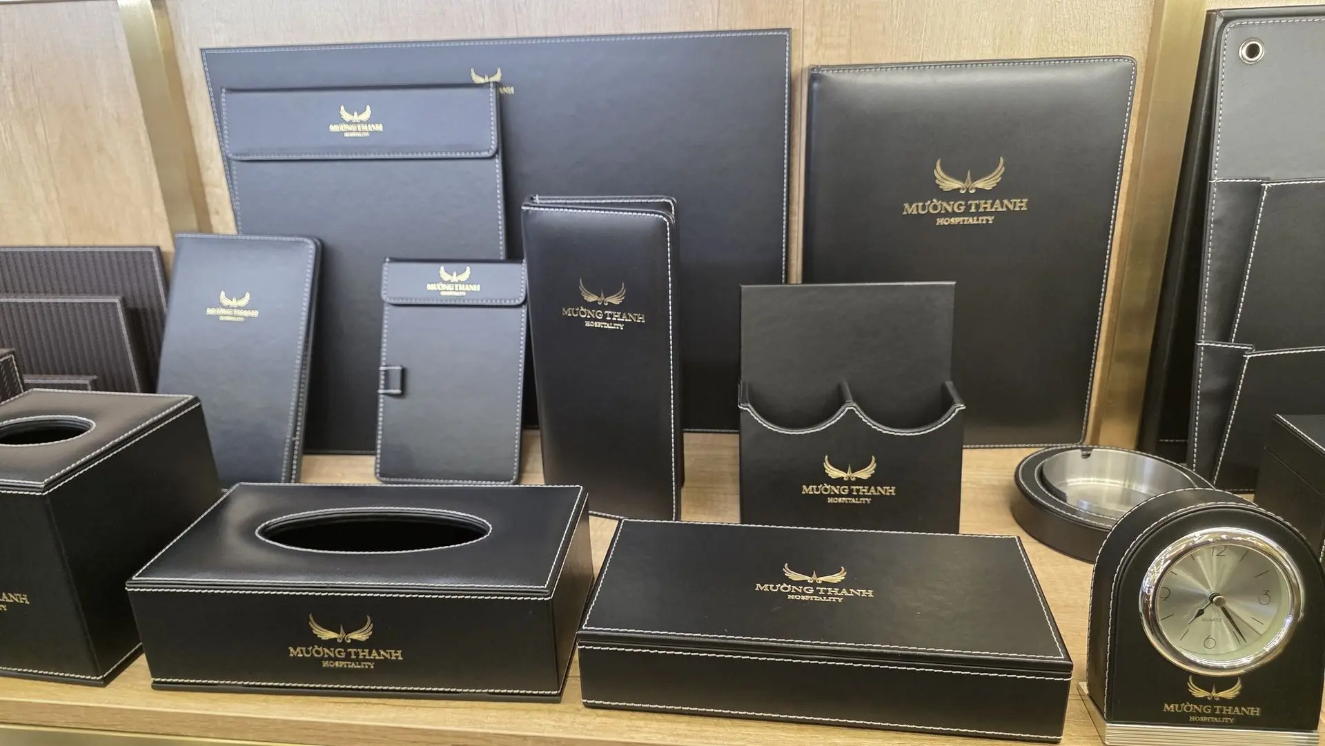 Custom leather hotel room amenities and desk stationery set with gold logo branding manufactured in China.