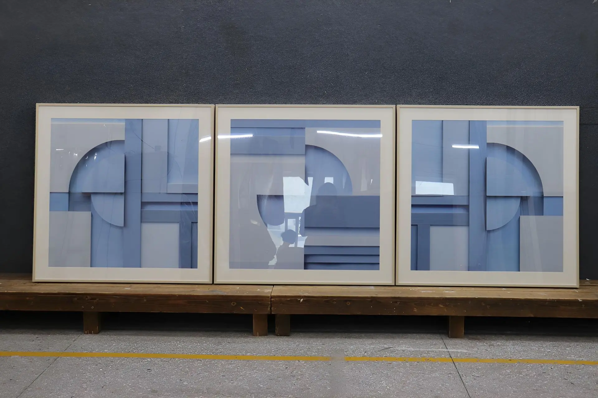Triptych of blue and grey geometric abstract wall art displayed in a gallery setting in China.