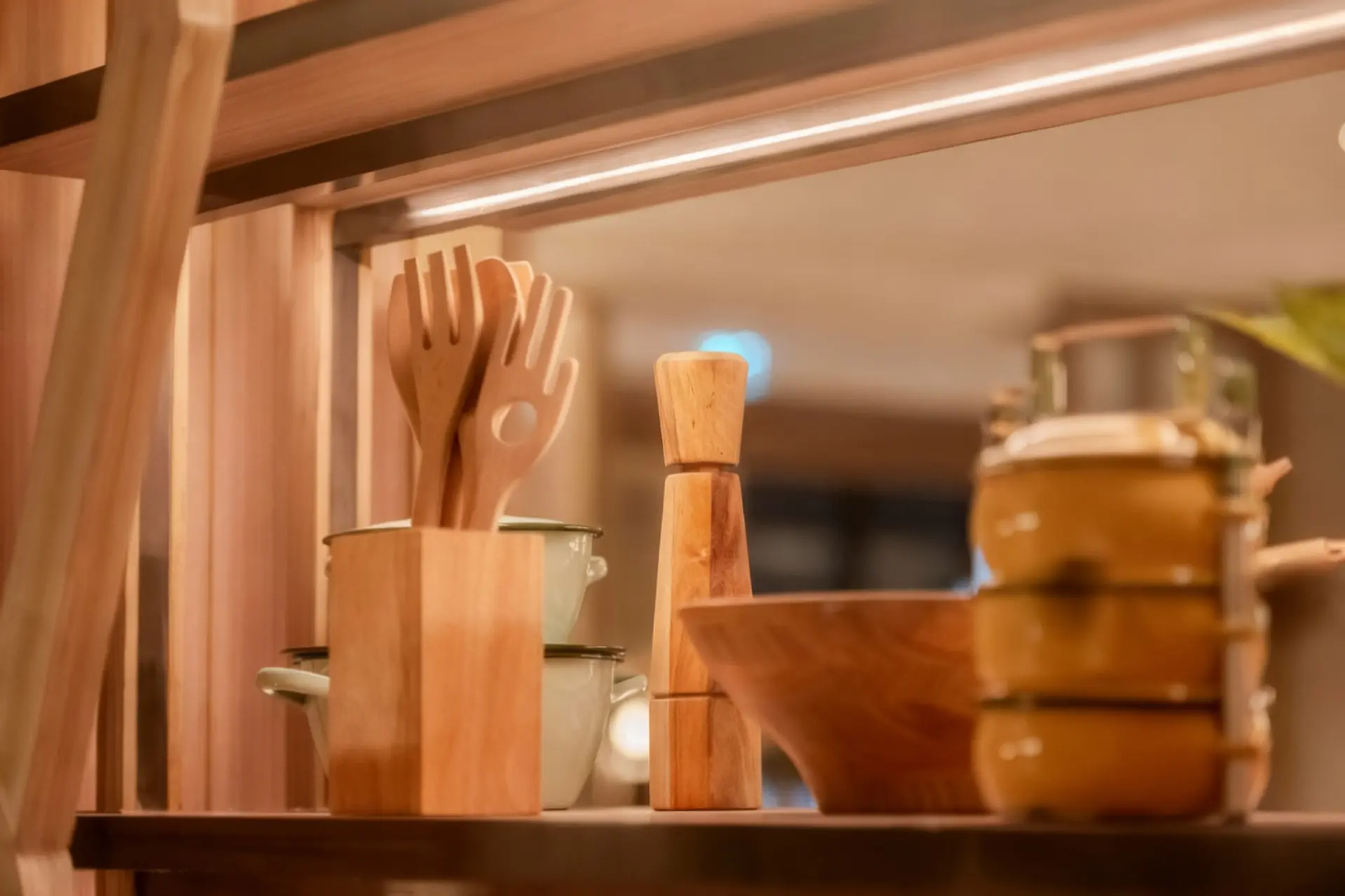 Modern wooden tableware set including salad servers, bowls, and a pepper mill on a shelf, high-quality craftsmanship from China.