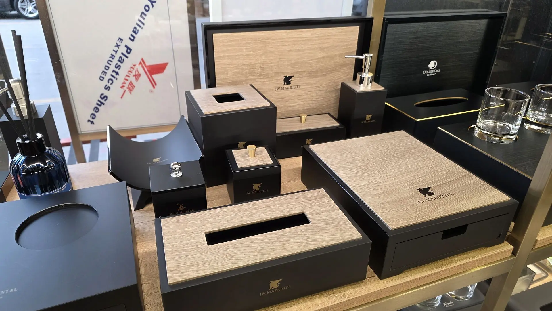Close-up of elegant hotel room accessories including a rectangular tissue box holder and soap pump with gold accents, sourced from a luxury provider in China.