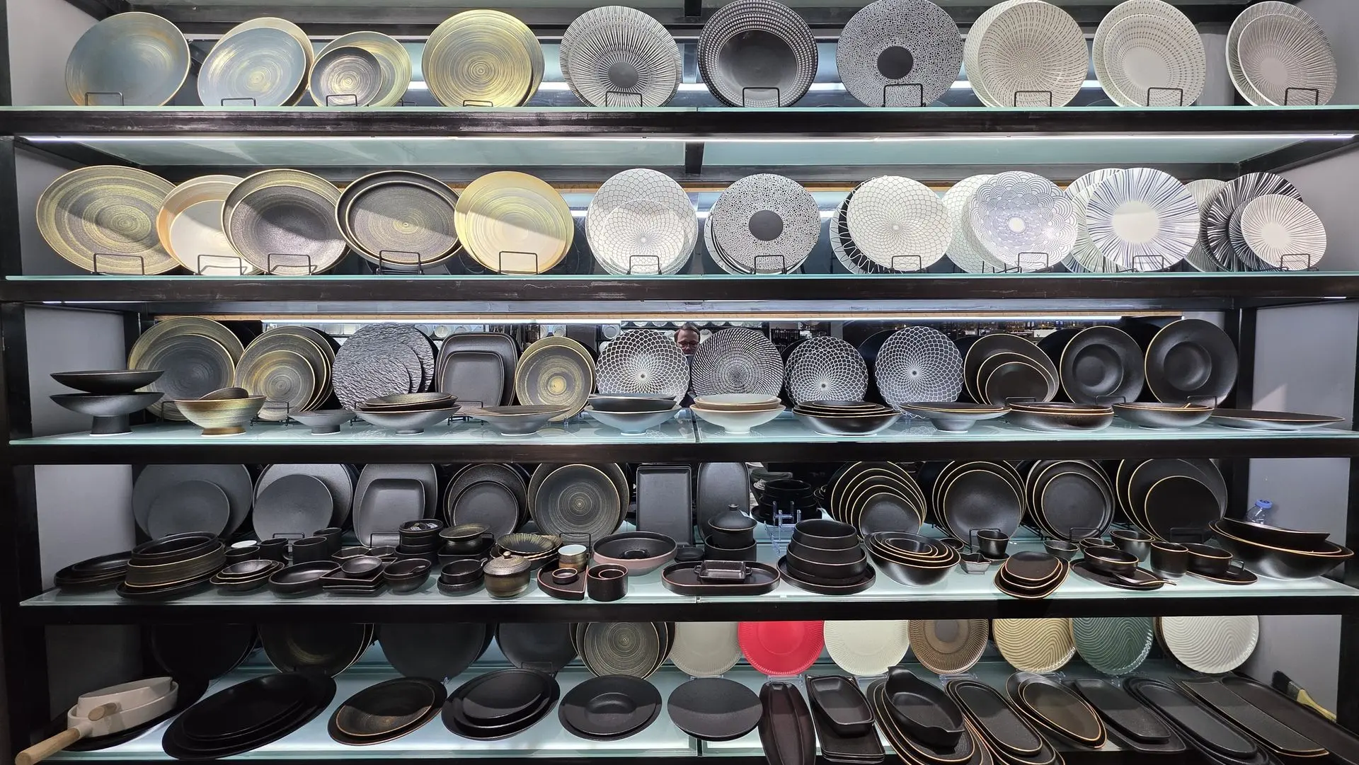 Modern ceramic dinnerware sets and fine China plates on luxury retail shelving.