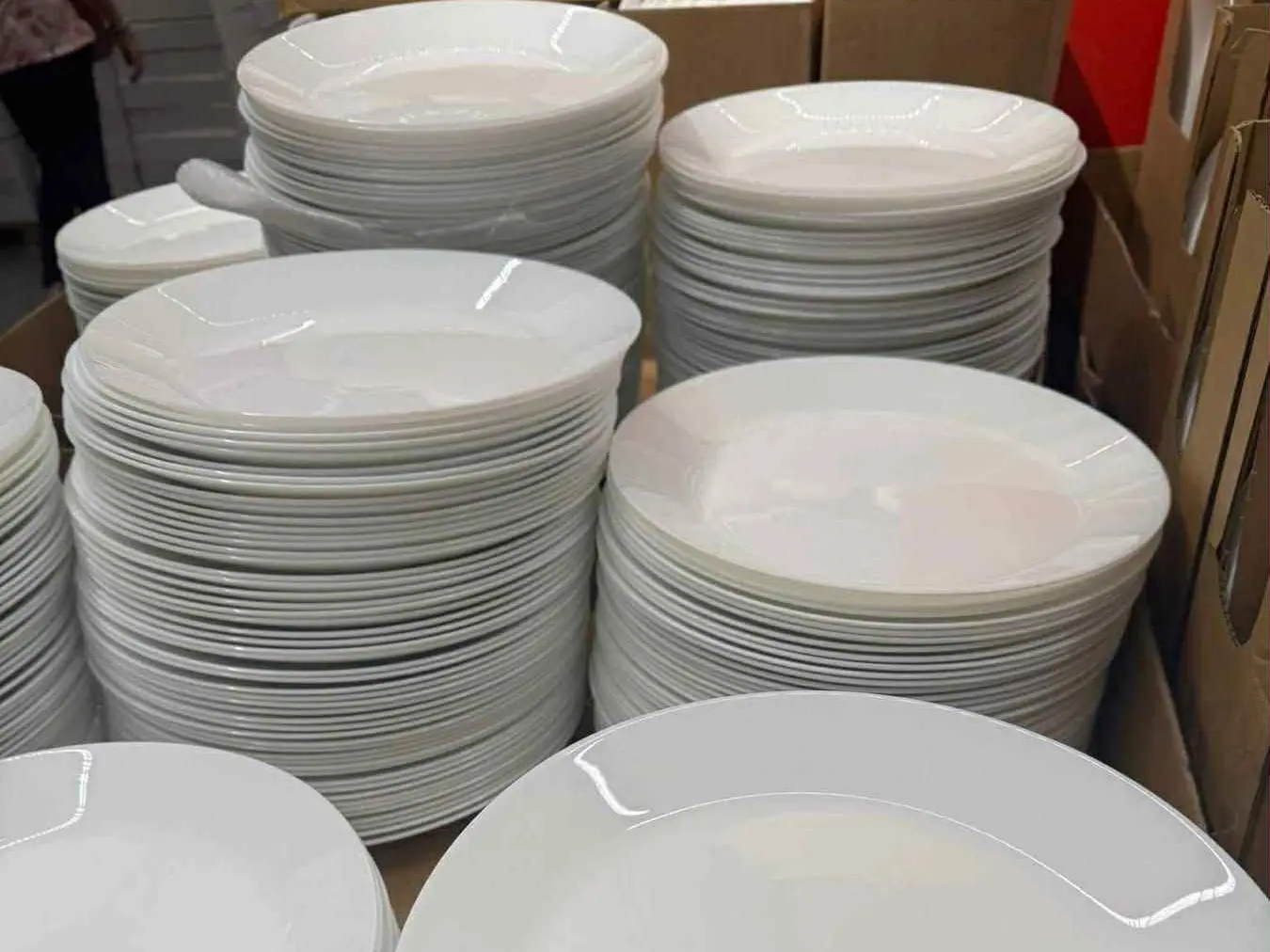 Bulk White China Crockery Dinner Plates Stacks of white ceramic china crockery plates in a retail warehouse setting