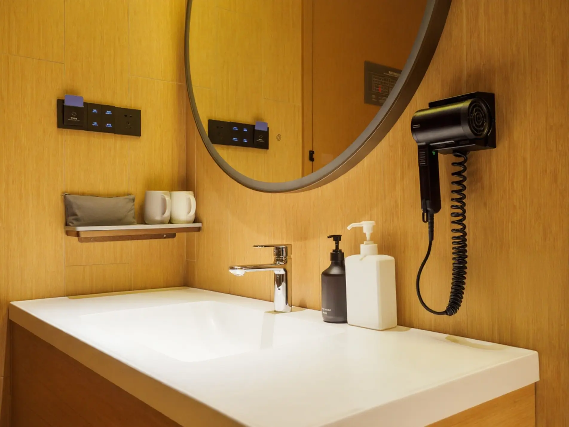 Evaluating Cost vs Quality: Wall-Mounted Hair Dryer in a Modern China Hotel Bathroom A sleek black wall-mounted hair dryer with a coiled cord installed in a modern China hotel bathroom featuring warm wood-paneled walls