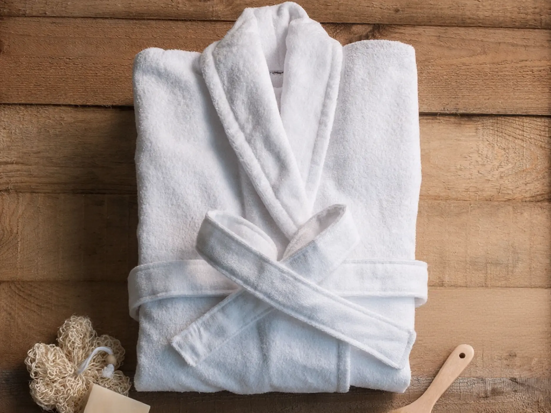 White Luxury Terry Cloth Bathrobe - CHINA OS&e Spa Collection Folded white cotton terry cloth bathrobe with belt on a wooden background, part of the CHINA OS&e hospitality spa essentials.