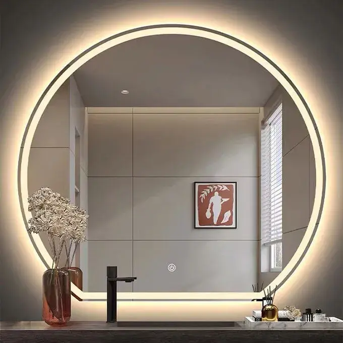 A modern round LED backlit mirror for a guestroom bathroom, manufactured in China, featuring a touch-sensitive power button and warm ambient lighting.