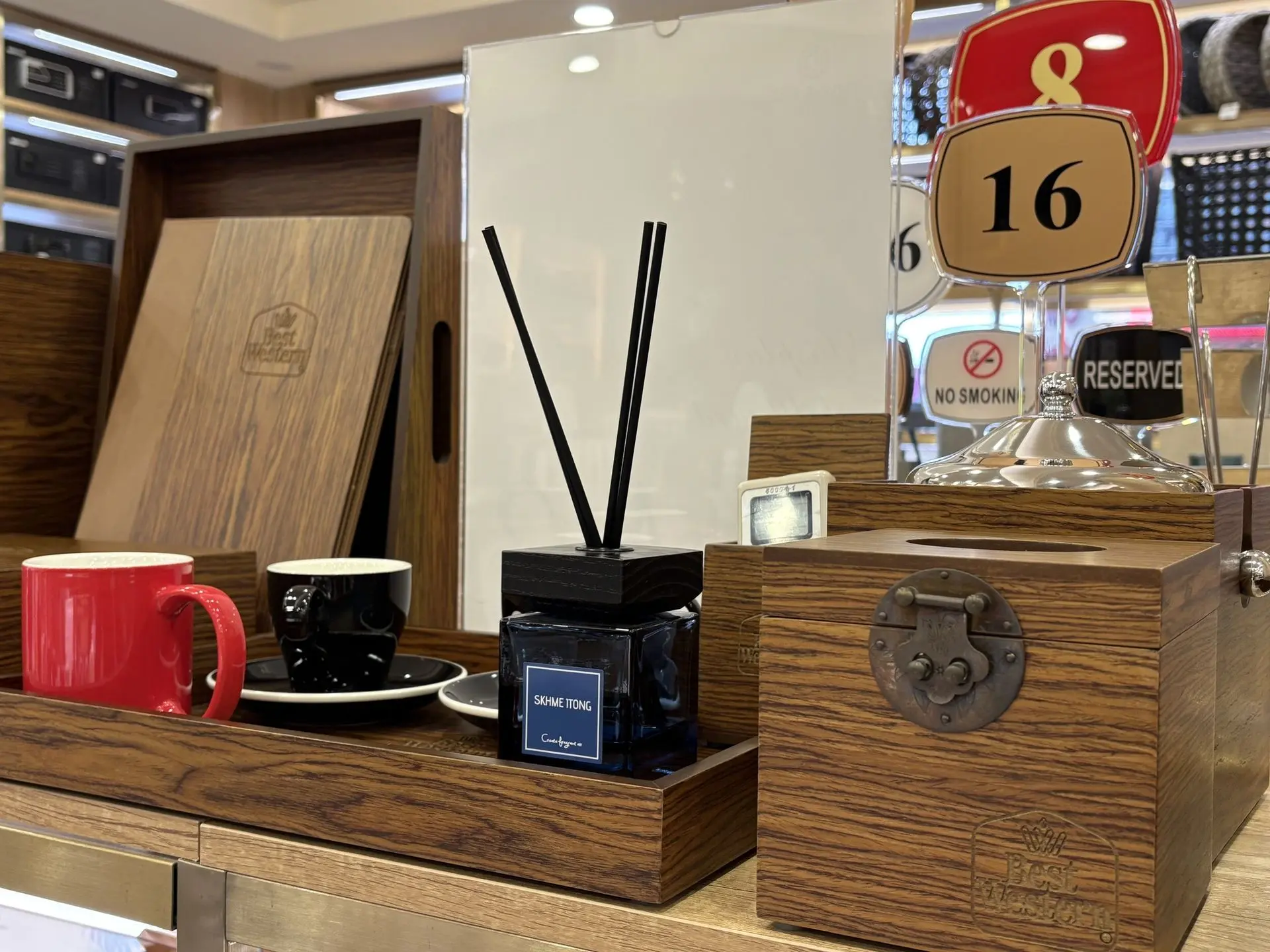 Luxury wooden hotel OS&E guest room supplies from China featuring a dark wood tray, reed diffuser, tissue box with antique brass latch, and ceramic coffee mugs.
