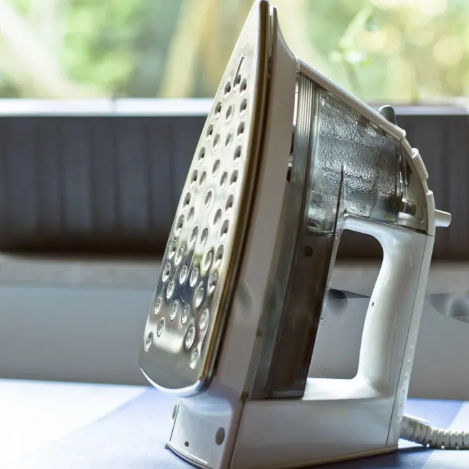 Professional Steam Iron - OS&E China Hotel Supplies Modern white and silver electric steam iron, high-quality OS&E China guest room equipment.