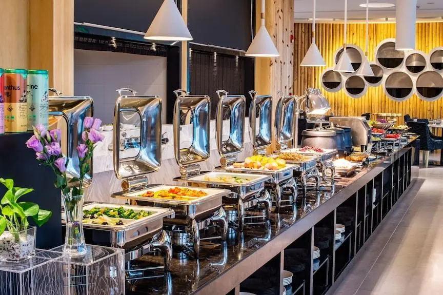 High-end commercial buffet equipment China setup featuring stainless steel chafing dishes and food warmers in a modern restaurant