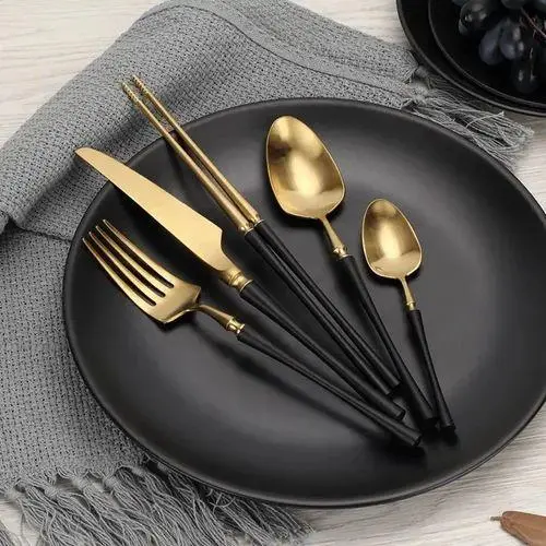 Elegant black plate displaying gold-finished cutlery, chopsticks, and hotel glassware China accessories